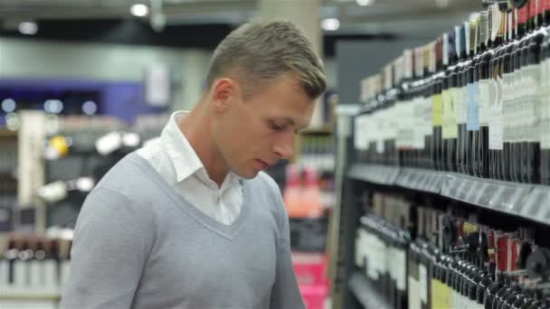 Homme souriant tout en faisant du shopping pour du vin — Video