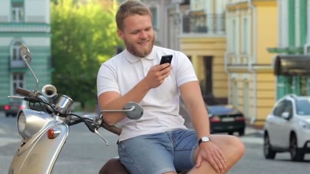 Handsome man is sitting on scooter — Stock Video