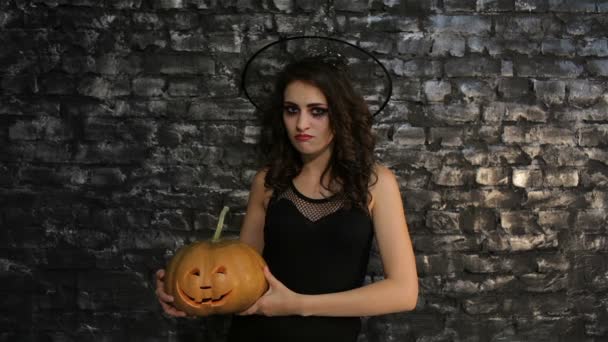 Woman-sorceress holds a pumpkin