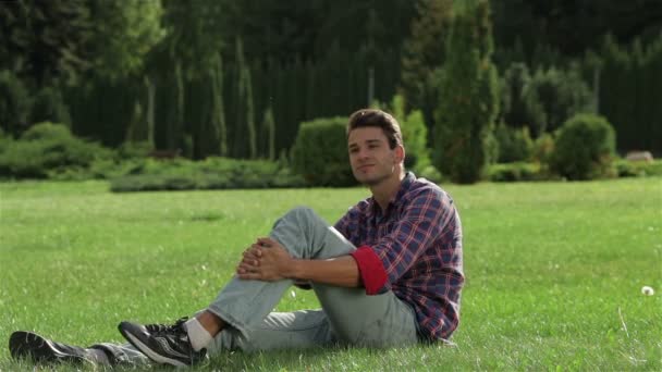 Een man genieten van een rust op het gras — Stockvideo