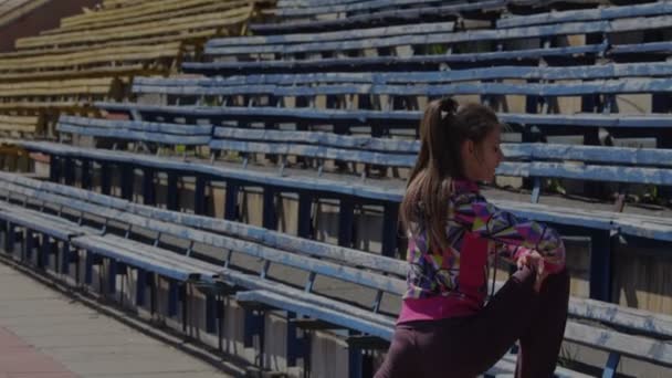 Stretching for legs and feet before the race in the stadium — Stock Video