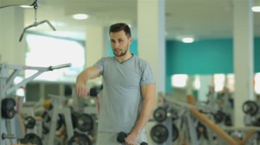Egzersiz 2 dumbbells ile yapan genç erkek