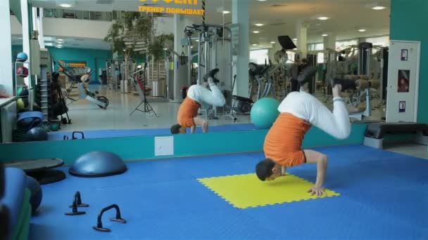 Joven haciendo ejercicio handstand — Vídeo de stock