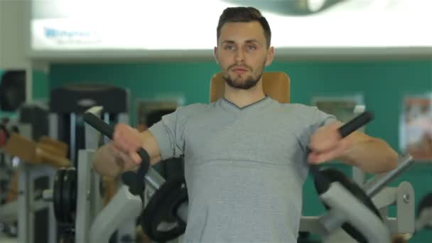 Глядя на камеру молодой человек делает упражнения для грудных мышц — стоковое видео