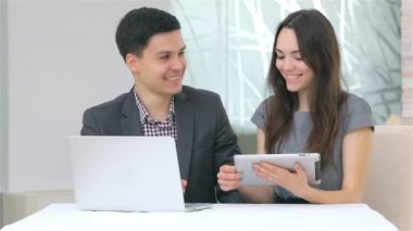 Çekici erkek ve kadın harmanlama veri tablet üzerinde tartışıyor