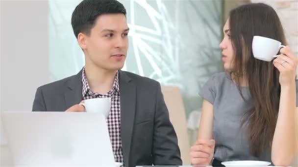 Young attractive business man and woman drink coffee — Stockvideo