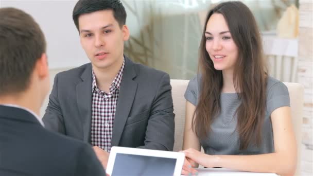 Jovem casal atraente consulta sobre seu projeto de negócios — Vídeo de Stock