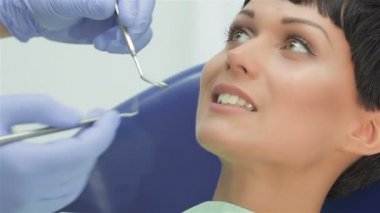 Diş hekimi diş dikkatle inceliyor hasta kız