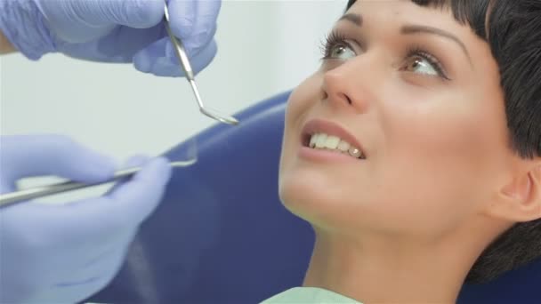 Dentista dentes examina cuidadosamente a menina paciente — Vídeo de Stock
