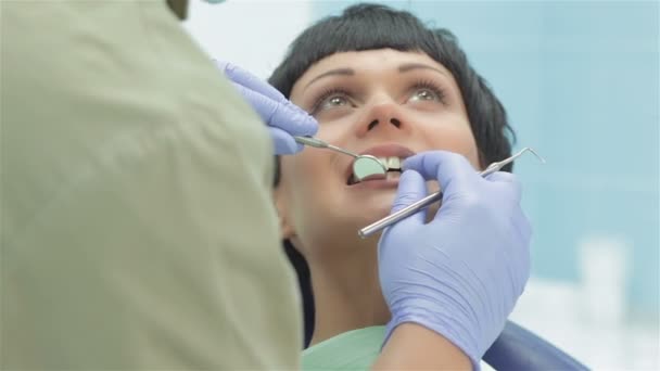 Tandarts permanent over de patiënt maakt haar tanden inspectie — Stockvideo