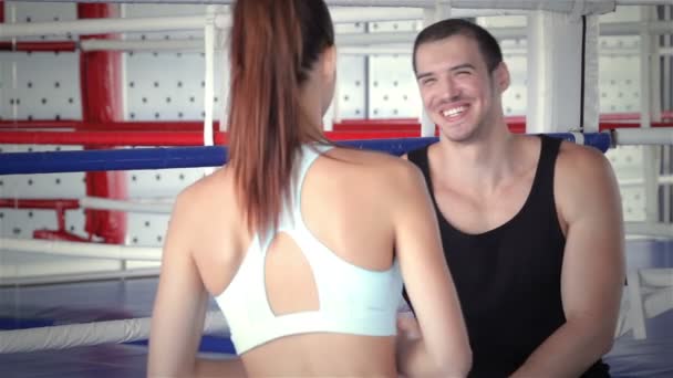 Sitzender Fitnesstrainer trifft seine junge Sportlerin und schüttelt ihr die Hand — Stockvideo