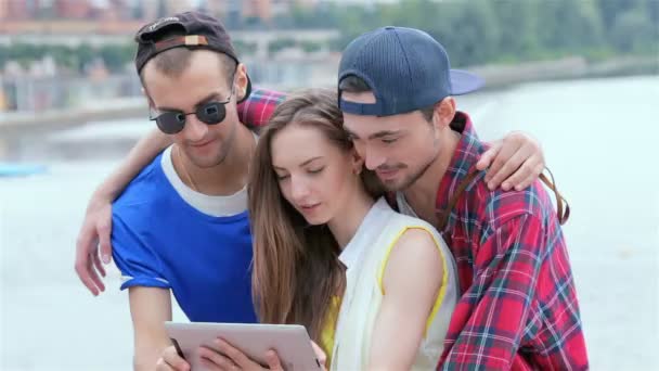 Freunde helfen dem Mädchen beim Umgang mit dem Tablet — Stockvideo