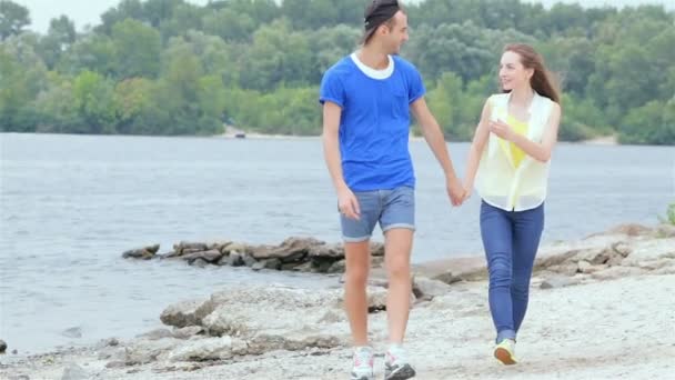 Meisje Guy sprong op zijn rug en ze rennen op het strand Slow Motion — Stockvideo