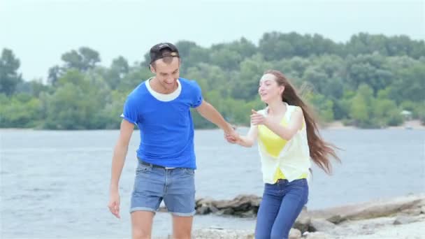 Meisje Guy sprong op zijn rug en ze rennen op het strand — Stockvideo