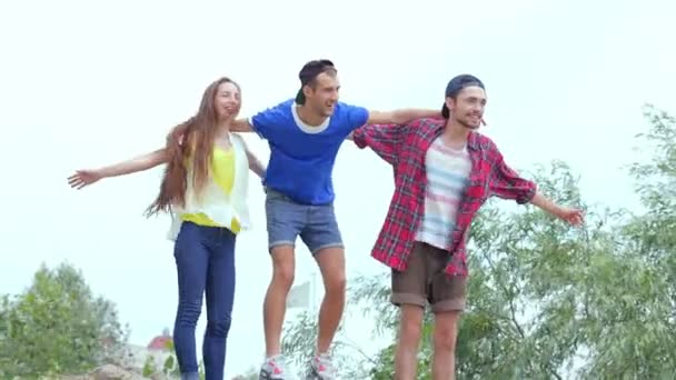 Trois amis debout sur les rochers de la rivière et battent des mains — Video