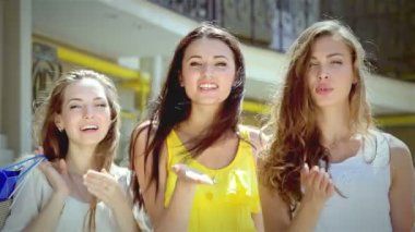 Üç genç kız shopaholic güneşli öpücük yapmak