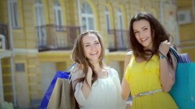 Alışveriş yaparken iki sevimli kız kız mutlu trendy alışveriş ile poz