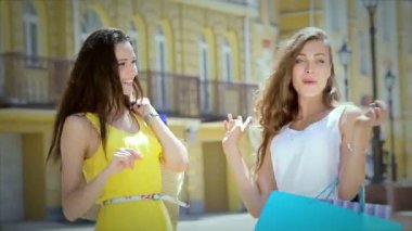 Poz alışveriş çantaları ile iki genç güzel kız arkadaş