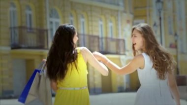İki kız Alışverişkoliğin taşımak çanta moda şeyler başa kamera ile