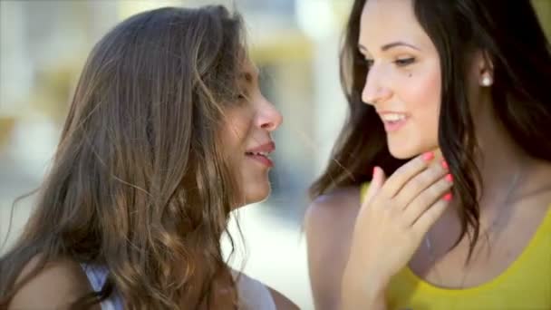 Две симпатичные девушки медленно шепчутся во время покупок — стоковое видео