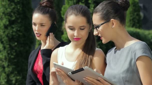 Mujer de negocios, trabajando en la tableta, una de las chicas mirando a la cámara — Vídeo de stock