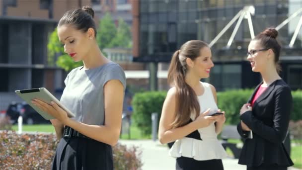 Business Woman läser nyheterna på bakgrunden av sina affärspartners — Stockvideo