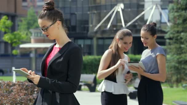 Femme d'affaires travaillant sur une tablette sur le fond de leurs partenaires d'affaires — Video