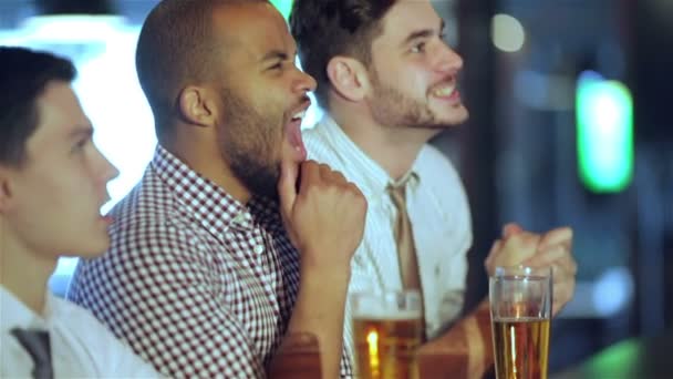 Шанувальники чоловіків дивляться футбол на телебаченні і п'ють пиво — стокове відео