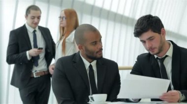 İki işadamı belgeleri tartışıyor