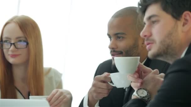 Quatro homens de negócios sorrindo bem sucedidos bebem café — Vídeo de Stock