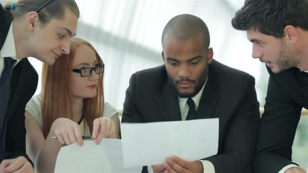 Biznesmeni siedzący przy stole w biurze, omawiając swoje czyny biznesowe — Wideo stockowe
