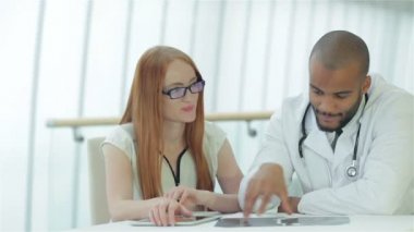 Doktor hastayla konuşuyor ve göğüs röntgenini elinde tutuyor.