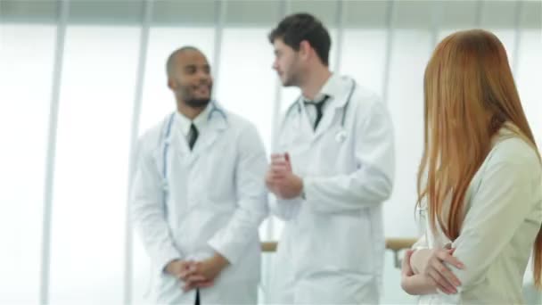 Три уверенных врача, осматривающих рентгеновский снимок легких в клинике — стоковое видео