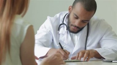 Gülümseyen doktor hastaya yeni bir ilaç reçete