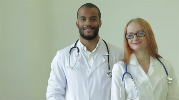 Два лучших врача улыбаются в камеру — стоковое видео