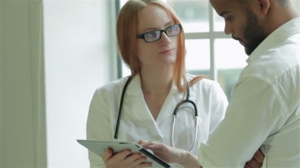 El médico de la ventana muestra los resultados de la prueba del paciente en el comprimido — Vídeo de stock