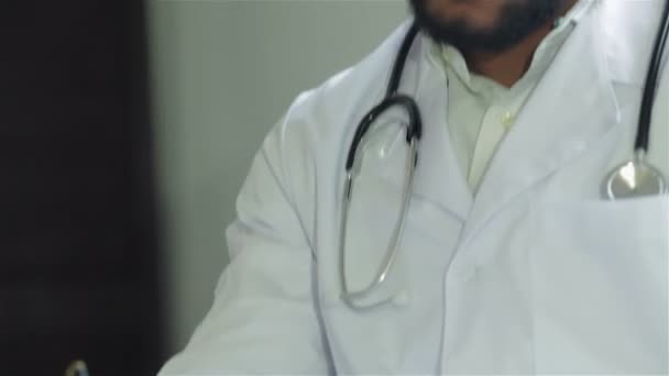 El médico extiende la mano y escribe sobre el examen del paciente — Vídeo de stock