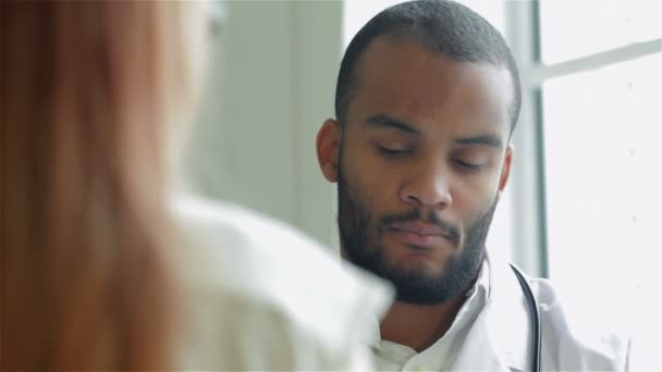 Un médico sostiene un soporte de papel en el examen del paciente — Vídeos de Stock