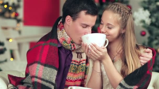 Ein liebendes Paar mit Tassen und Getränken zu Weihnachten — Stockvideo