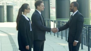 Yeni ortaklara hoş geldin. Resmi kıyafetler içinde gülümseyen iş adamları grubu