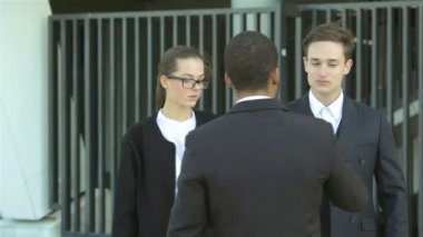 Yeni ortaklara hoş geldin. Resmi kıyafetler içinde gülümseyen iş adamları grubu