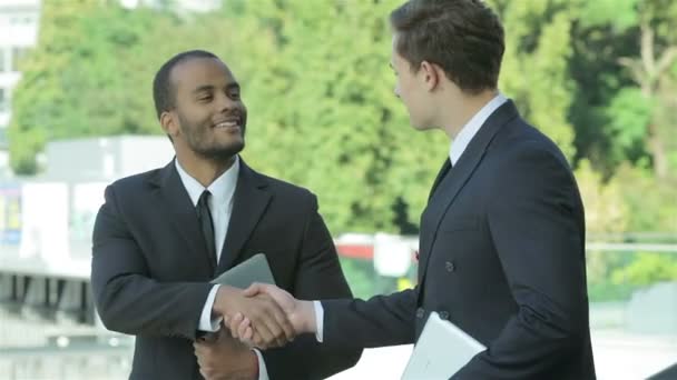 Два уверенных бизнесмена пожимают друг другу руки — стоковое видео