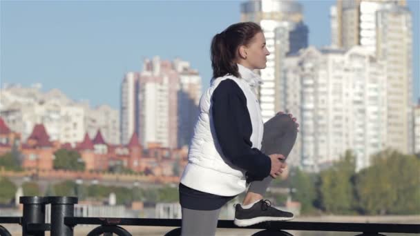 Vista de una joven estirándose sobre un puente a pie — Vídeos de Stock