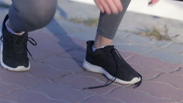Νεαρή αθλήτρια που δένει αθλητικά παπούτσια κατά την προπόνηση έξω — Αρχείο Βίντεο
