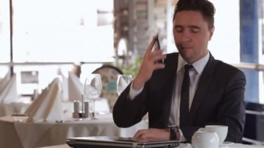 Öğle yemeğinde bir adam telefon alır.