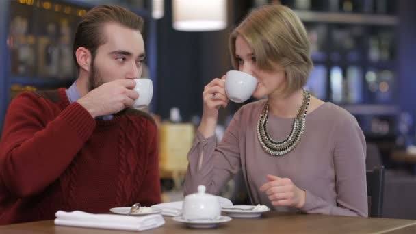 Retrato de joven hermosa pareja enamorada tomando café en hermosa cafetería — Vídeos de Stock