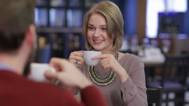 Pareja joven sentada en un café tomando café y té — Vídeos de Stock
