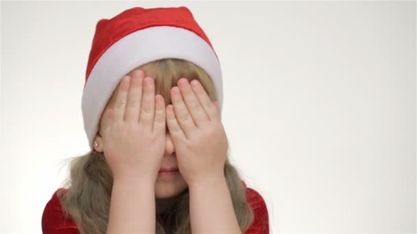 Kind bedekt haar gezicht met haar handen en lacht — Stockvideo