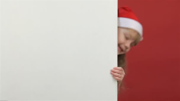 Niño mirando hacia fuera desde detrás de un lugar de copia blanca — Vídeos de Stock