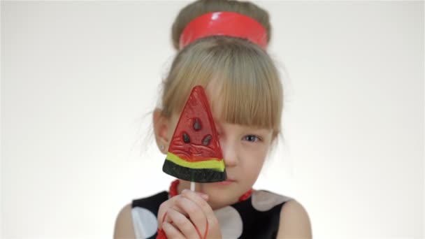 Дівчина прикриває очі льодяником — стокове відео
